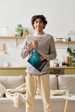 Yakışıklı bir genç adam evinde bir içki ve bir dergi ile rahatlar..