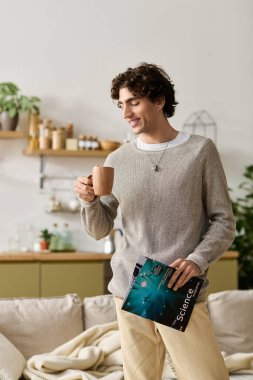 Kıvırcık saçlı yakışıklı bir adam evde rahatlıyor, kahvesini yudumluyor ve dergi okuyor..