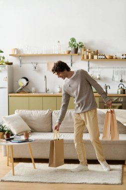 Modern bir dairede yakışıklı bir genç adam yeni alımlarını evde dinlenirken keşfediyor..