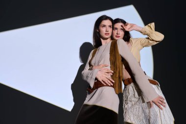 İki güzel ikiz kız kardeş zarif bir şekilde şık bir şekilde poz verir..