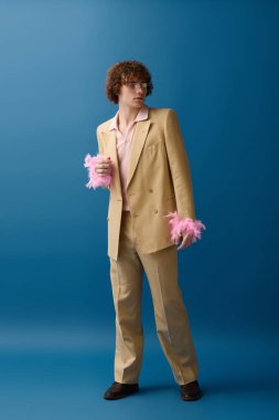 Şık bir genç kendine güvenerek duruyor, eşsiz giysiler içinde, gençlik enerjisi yayıyor..