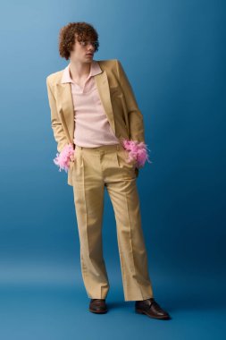 Şık giyinmiş enerjik bir çocuk dinamik bir poz veriyor cesur mavi bir arka plana karşı, coşkulu bir şekilde..