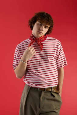 Genç çocuk, stüdyo ortamında dinamik bir poz verirken modaya uygun kıyafetlere güveniyor..