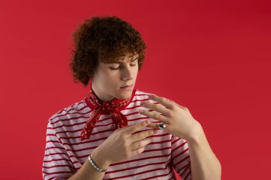 Genç çocuk cesur bir arkaplana karşı vurucu bir halka ayarlarken kendine güvenerek poz veriyor.