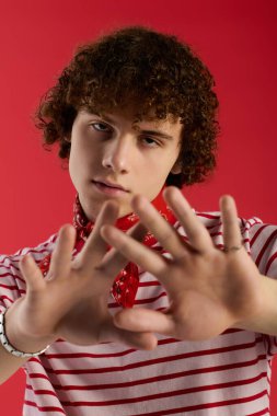 Genç, enerjiyi eşsiz bir pozla yakalıyor ve canlı bir arka planda şık bir kıyafet giyiyor..