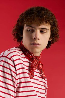 Şık bir genç kendine güvenerek poz verir. Moda kıyafetinin ve enerjik havasının altını çizer..