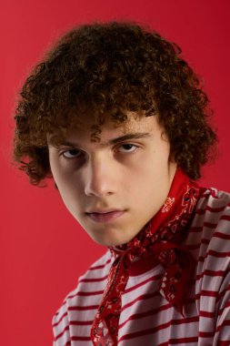 Kıvırcık saçlı, kendine güvenen, gençlik enerjisi ve cazibesi saçan modaya uygun bir genç..