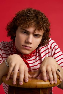 Şık çizgili gömlekli ve kırmızı bandanalı genç, moda anlayışını ön plana çıkarıyor..