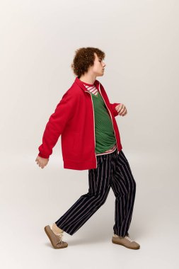 Şık giyinmiş dinamik bir genç, kendine güvenerek yürüyor, bireyselliğini ve yeteneğini ifade ediyor..