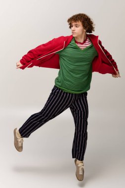 Genç bir çocuk şık bir şekilde poz verirken kendine güvenir ve aktif bir anı yakalar..