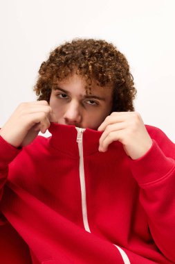 Genç çocuk canlı kırmızı bir fermuarla dikkatleri çekiyor, tarzını ve özgüvenini yaratıcı bir şekilde ifade ediyor..