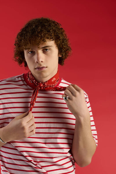 Teenager displays confidence with stylish red bandana and striped shirt in a vibrant setting.