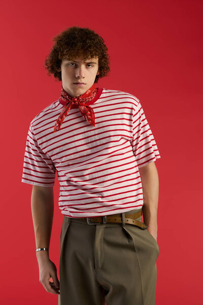 Stylish teenager poses dynamically in striped shirt and bandana, radiating youthful energy.