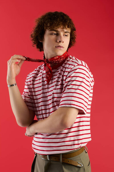 A confident teen shows off a trendy outfit against a vibrant red backdrop.