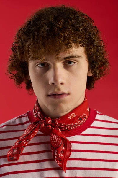 Şık bir genç cesur kırmızı arka planda kendine güvenen bir poz veriyor..