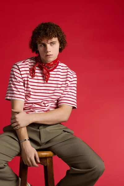 Zeki giyimli genç dinamik bir poz veriyor, kendine güven ve enerji saçıyor..