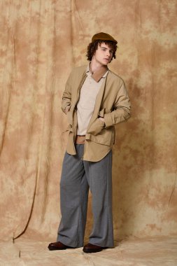 Yakışıklı genç adam, sanatsal bir ortamda özgüvenle, modern modayı sergiliyor..