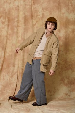 Yakışıklı genç, desenli bir arka planda eşsiz bir stil sergiliyor..