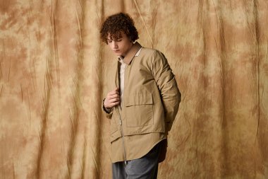 Şık bir genç zarif pozlar veriyor çarpıcı bir arkaplana karşı.