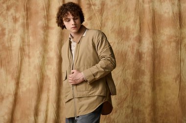 Kendine güvenen genç adam modern modayı sıcak bir ortamda sergiliyor..