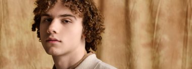 Yakışıklı genç zarif poz veriyor, modaya uygun tarzını sıcak bir zemine vurguluyor..