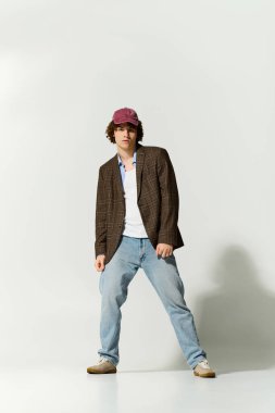Yakışıklı genç, kendine güveni tam, spor ceketi ve şapkasıyla eşsiz bir tarz sergiliyor..