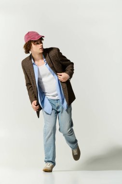 Yakışıklı ergen, poz verirken gündelik ve şık bir moda karışımıyla modern tarzı kucaklıyor..
