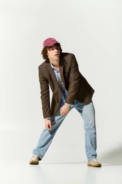 Yakışıklı ergen kendine güvenerek poz verir, gündelik ve resmi stilleri neşeli enerjiyle harmanlar.