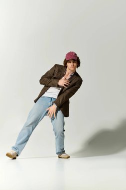 Yakışıklı ergen, rahat bir pozda şık ve rahat bir şekilde harmanlıyor..