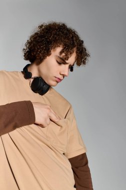 Modayı takip eden genç, havalı kulaklıklarla benzersiz detaylara dikkat çekerken moda kıyafetler sergiliyor..