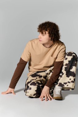 Yakışıklı genç, canlı desenler ve renkler içeren günlük kıyafetlerle yaratıcı bir şekilde poz veriyor..