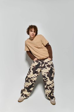 Yakışıklı genç, kendine güvenen bir şekilde poz veriyor. İçeriden moda yayıyor..