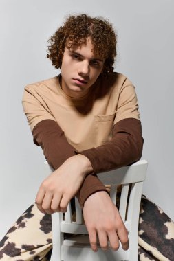 Yakışıklı genç, temiz bir stüdyo içinde şık bir gardıropta güven içinde poz veriyor..