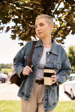 Genç ve güzel bir kadın, güneşin altında kahvesinin tadını çıkararak, rahatça dışarı çıkar..