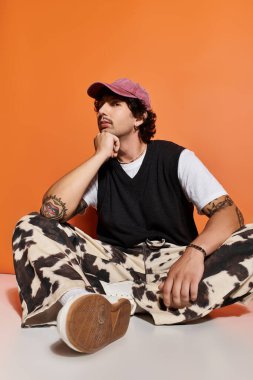 Şık giyinmiş yakışıklı bir genç adam, gündelik bir şekilde otururken....