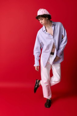 Genç adam rahat bir poz ve çarpıcı bir arka planla şık tarzını sergiliyor..