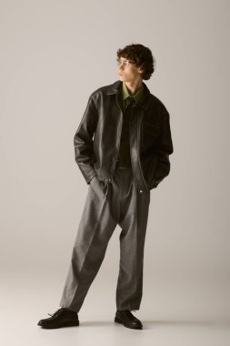 Genç adam eşsiz moda anlayışını yaratıcı bir fotoğraf çekimi sırasında minimalist bir ortamda sergiliyor..