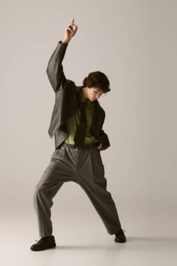 Genç bir adam dinamik bir poz verirken şık kıyafetini sergiliyor..