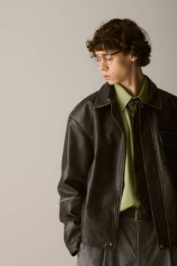 Yakışıklı genç adam kendine güveni tam, modaya uygun kıyafetleri ve gözlükleriyle modern modayı gösteriyor..