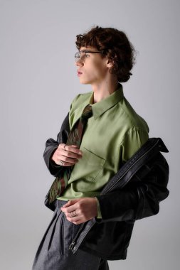 Genç adam benzersiz moda anlayışını modern kıyafetler ve çarpıcı aksesuarlarla sergiliyor.