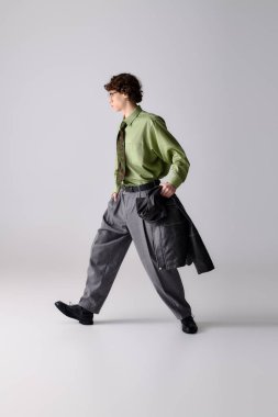 Kendine güvenen genç adam, modaya uygun bir şekilde zarif adımlar atıyor, benzersiz tarz seçimleri sergiliyor..