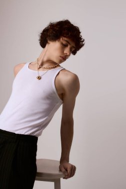 Genç bir adam kendine güveni tam, modaya uygun bir kıyafetle eşsiz tarzını sergiliyor..