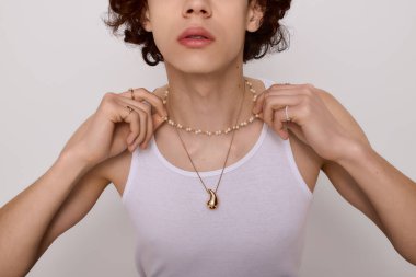 Genç adam kendine güvenerek şık ve modern bir ortamda şık mücevherlerini sergiliyor..