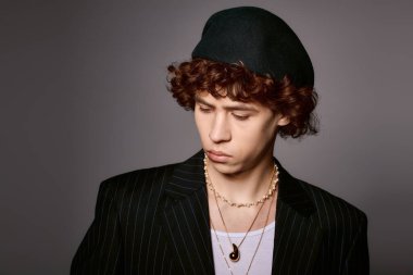 Genç bir adam şık bir elbise ve aksesuar sergiliyor..