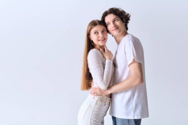 Mutlu bir çift birbirine gülümser, gri bir stüdyo ortamında aşk saçar..