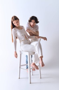 Genç çift birlikte neşeli bir anı paylaşıyor, basit bir ortamda sevgi ve rahatlık yayıyorlar..