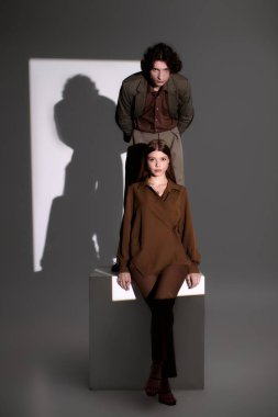 Şık genç çift, şık kıyafetlerini minimalist bir stüdyoda sergiliyor..