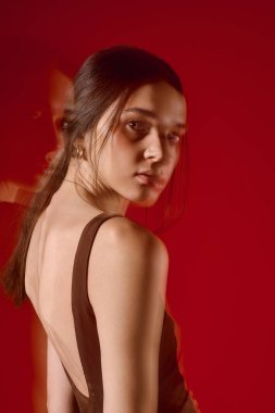 Güzel bir kadın zarif bir şekilde duruyor, kendine güveni ve cazibesi ile modern moda sergiliyor..