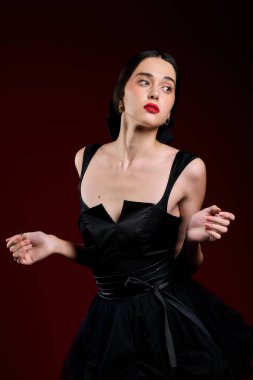 Çekici kadın büyüleyici siyah elbisesiyle güzelliğini sergiliyor, özgüven ve zarafet saçıyor..