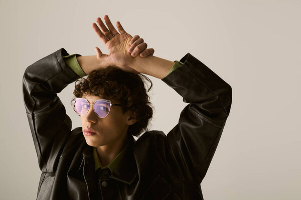 Молодой красивый мужчина демонстрирует свое чувство стиля, позируя на простом фоне.